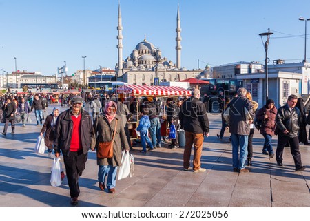 ISTANBUL, TURKEY - APRIL 10, 2015: square with food stall at the banks of the Golden Horn with the New Mosque in the background and unidentified people. Istanbul is the largest city in Turkey