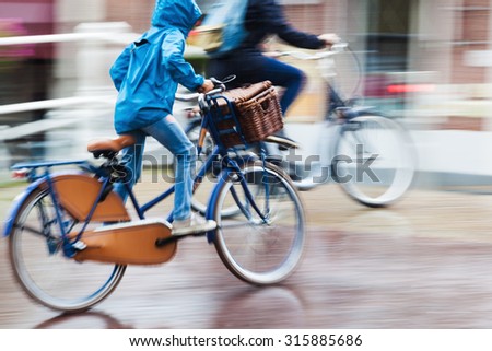 bicycle rider at a rainy day in the city in motion blur
