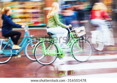 woman in motion blur riding bicycle in the rainy city