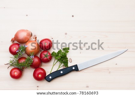 vegetables and herb with a kitchen knife on a wood board