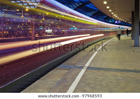 night photo of a departing train at the train station with motion blur