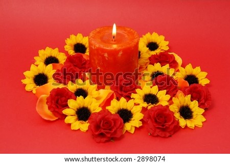 Romantic red candle and flowers on red