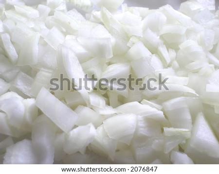 Raw chopped white onions on a white cutting board, ready for making a delicious meal.