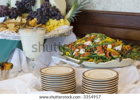 Salad and crackers with stacks of small salad plates ready for a buffet style dinner.