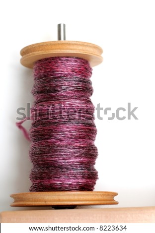 Hand dyed and hand spun yarn on wooden bobbins.