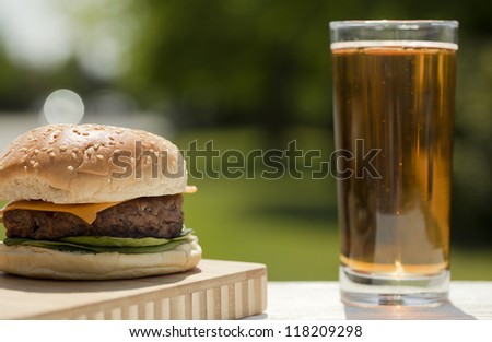 Close-up image of a hamburger sandwich with a glass ice tea