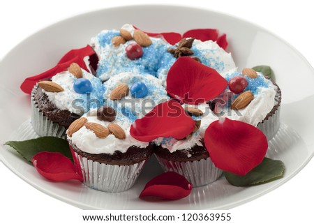 Close up image of chocolate cupcakes with rose petal on white plate against white background
