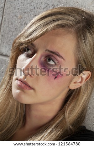 Close up image of an abused woman having a black eye and wound on her face