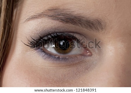Close-up image of a woman\'s eye with eye shadow looking at the camera