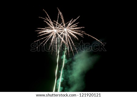 Green smoke wafts away from the exploding fireworks