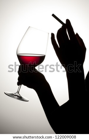 Human drinking and smoking in a silhouette image - stock photo
