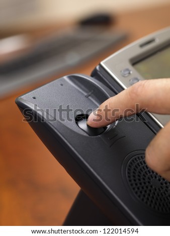Close-up shot of human finger disconnecting black land line phone.