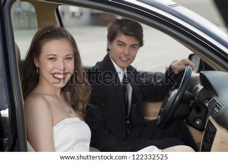 Close-up image of a romantic couple smiling while sitting inside the car
