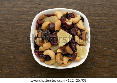 Overhead shot of a bowl of dried nuts and fruits on the wooden table