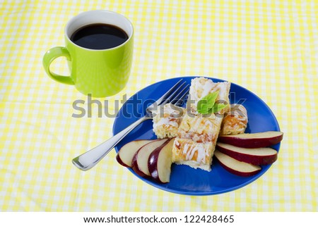 Pie served with a mug of coffee over table cloth.