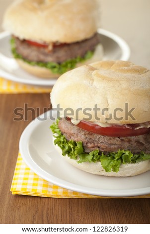 Cropped image of a chicken burger with slice tomato and lettuce