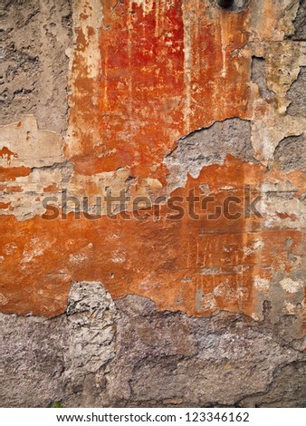 Orange shapes on a wall made from bits of painted plaster