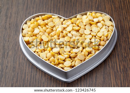 Image of yellow beans on a heart shape container isolated