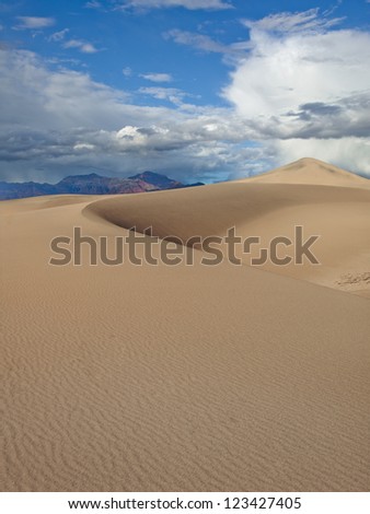 A big sand dune rises above the ground in Death Valley, USA.