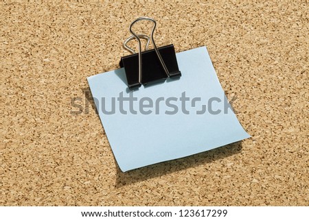 Close up image of blue adhesive paper with paper clip