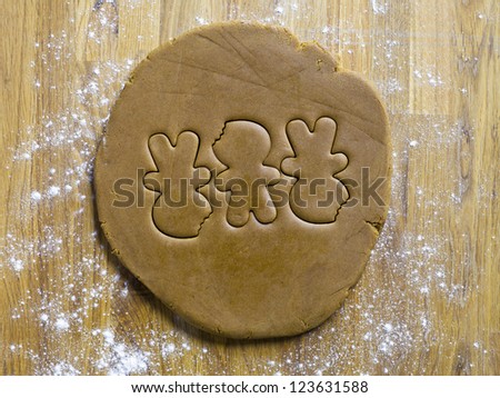 Three ginger bread man shape on a dough