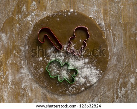Overhead shot of cookie cutters on dough over the wooden table