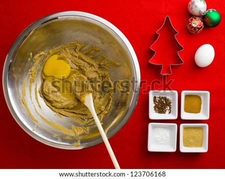 Close-up top view of a cake ingredient with spatula and bowl over red background.