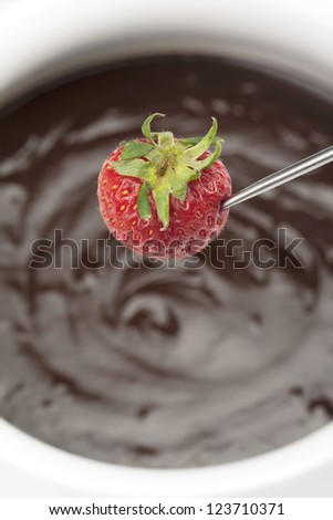 Cropped image of strawberry on stick and chocolate sauce isolated on a white background