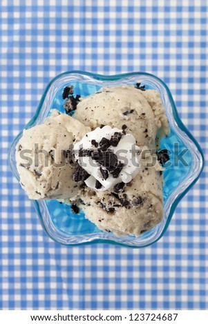 Overhead shot of a cookies and cream ice cream on a blue cup