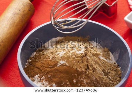 Baking powder and chocolate powder on a blue bowl and other baking utensils