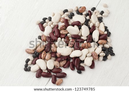 Assorted beans with white beans, red beans, black beans and haricot beans scattered over the white background