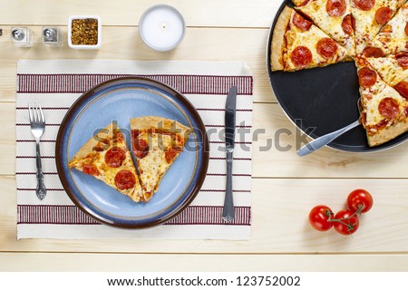 Top view of slice of pizza in plate on a restaurant table.
