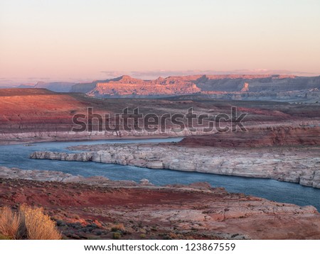 Scenic shot of mountain range and water stream with clear sky in background.