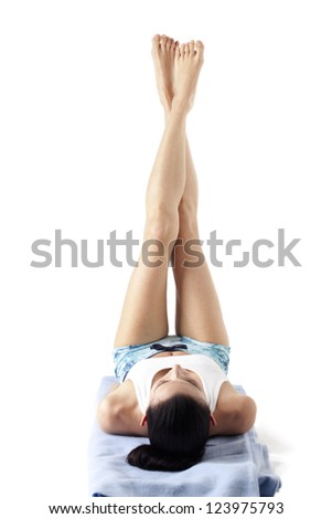 View of healthy young woman doing a yoga pose with feet in the air