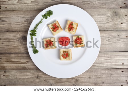 Tomato Bruschetta arranged in a plate like a star with half tomato at the center