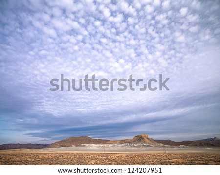A plain with some mountains in the background and a lot of sky in the frame.