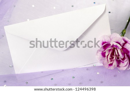 Horizontal image of white invitation card with a purple carnation flower on the side