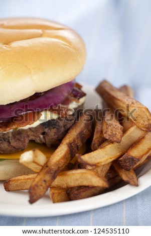 Close-up image of a burger sandwich and potato fries