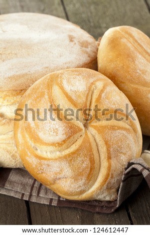 Close-up image of a group of bread in the brown cloth on the wooden table