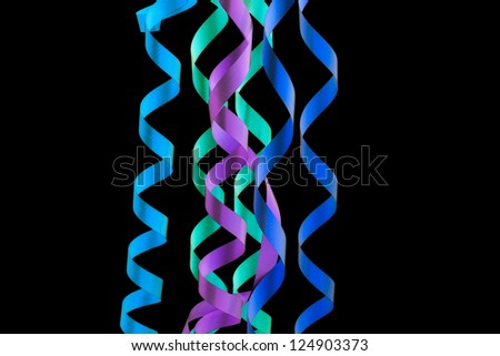 Multi-colored party streamers isolated over black background