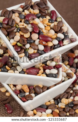 Close-up shot of three plastic bowls of variety of food grains on top of each other.
