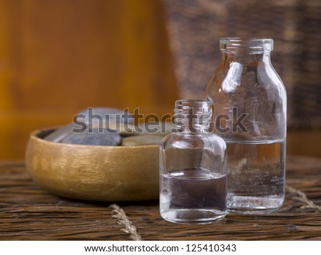 Close-up image of spa massage stones with essential oil on the wooden table