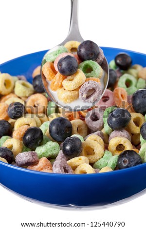 A colorful cereal with blueberries and milk in blue bowl against white background