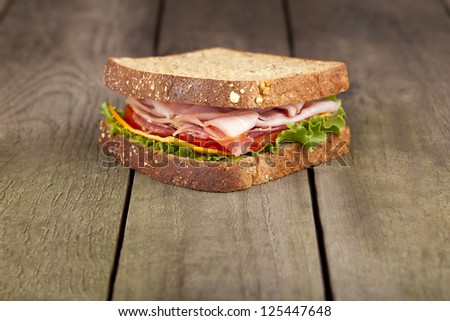 BLT sandwich on wholegrain bread on a brown background