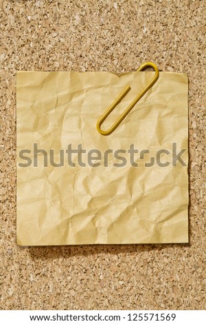 Image of crumpled yellow adhesive paper with paper clip