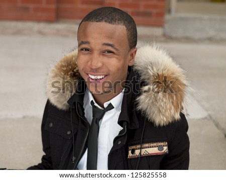 Shot of a young man laughing in a winter jacket.