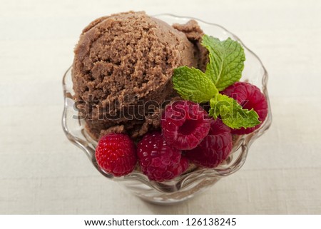 Close up and top view image of chocolate ice cream bowl with several strawberries