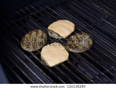 Close-up image of a grilled burger patties with slice cheese