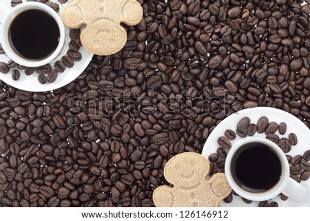 Close-up shot of coffee cup with black coffee with gingerbread cookies and coffee beans.