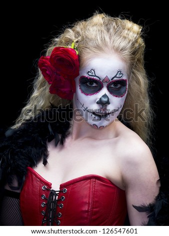 Portrait image of a scary woman wearing face make-up and roses over dark background.